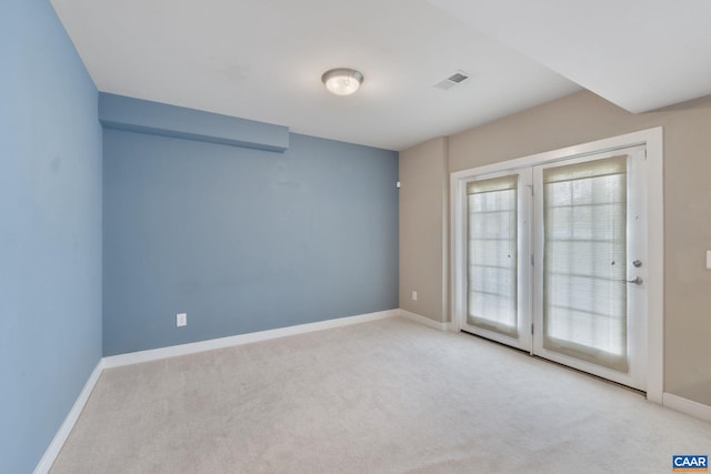 carpeted empty room featuring baseboards and visible vents