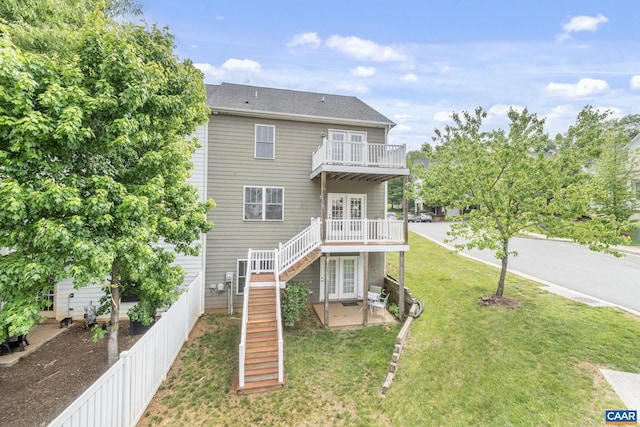 view of front of home with a front lawn, a wooden deck, stairway, a patio area, and french doors