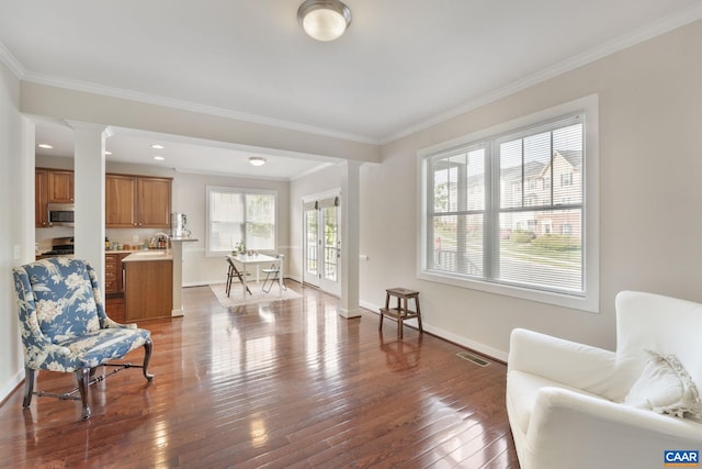 living area with crown molding, ornate columns, baseboards, and dark wood-type flooring