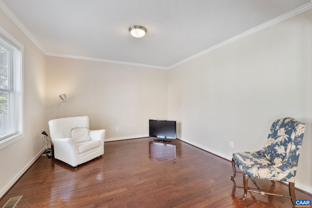 sitting room with crown molding, baseboards, wood finished floors, and visible vents