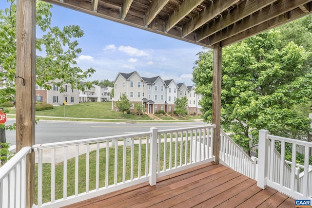 wooden terrace featuring a porch, a lawn, and a residential view