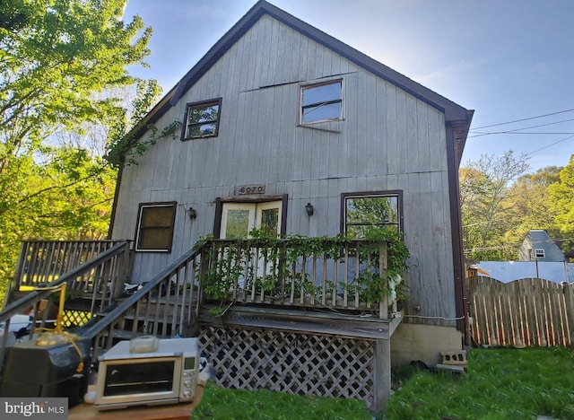 back of property featuring fence and a wooden deck