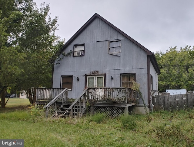 rear view of property with fence and a wooden deck