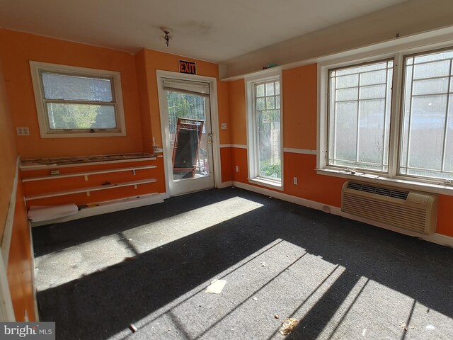 spare room featuring baseboards and a wall mounted AC