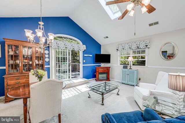 carpeted living area featuring visible vents, plenty of natural light, ceiling fan with notable chandelier, and a skylight