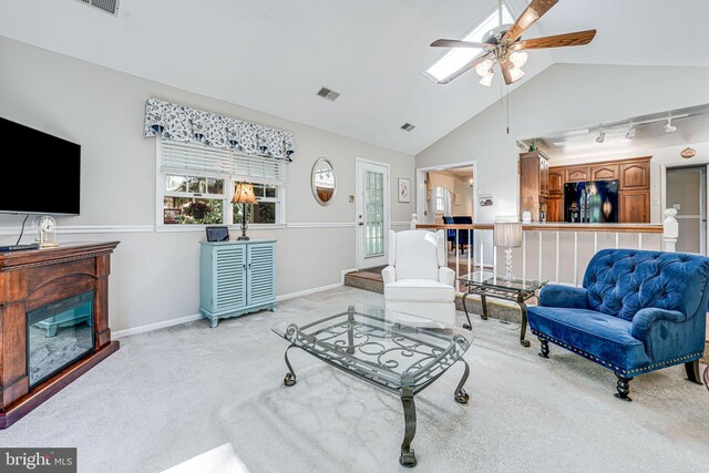 carpeted living area featuring ceiling fan, visible vents, baseboards, and lofted ceiling