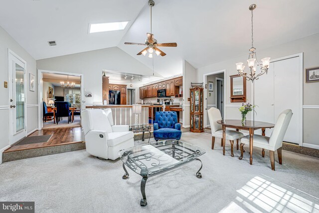 living room featuring light carpet, high vaulted ceiling, ceiling fan with notable chandelier, baseboards, and visible vents