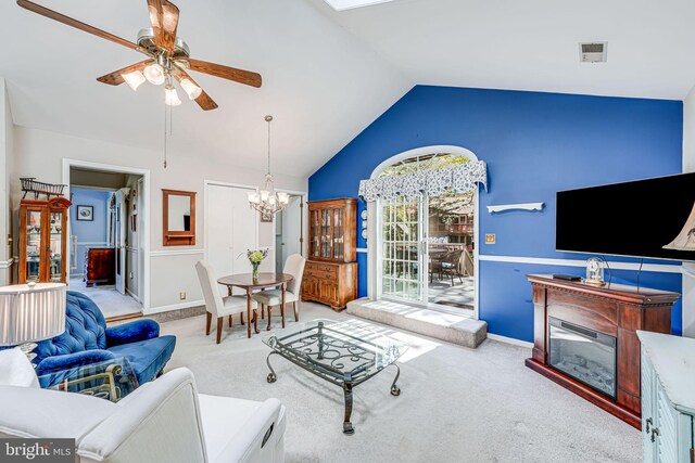 carpeted living room with visible vents, baseboards, ceiling fan with notable chandelier, and vaulted ceiling