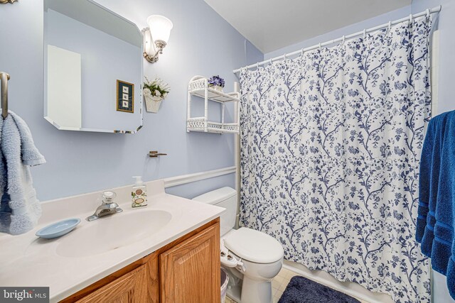 bathroom featuring toilet, tile patterned floors, curtained shower, and vanity