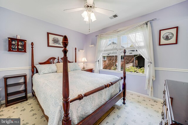 carpeted bedroom with a ceiling fan, baseboards, and visible vents