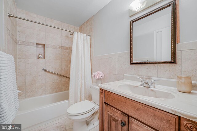 full bathroom with toilet, tile walls, shower / tub combo with curtain, and vanity