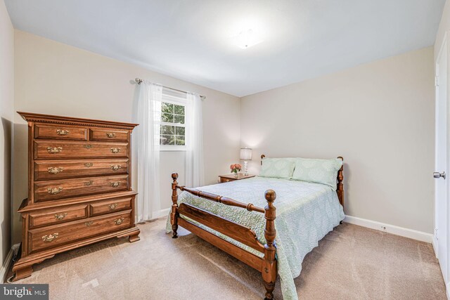 bedroom featuring baseboards and light colored carpet