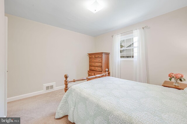 carpeted bedroom with visible vents and baseboards