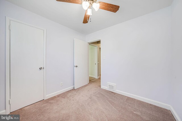 unfurnished bedroom with baseboards, carpet flooring, a ceiling fan, and visible vents