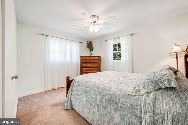 carpeted bedroom featuring baseboards and a ceiling fan