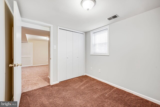 unfurnished bedroom with baseboards, visible vents, carpet, and a closet