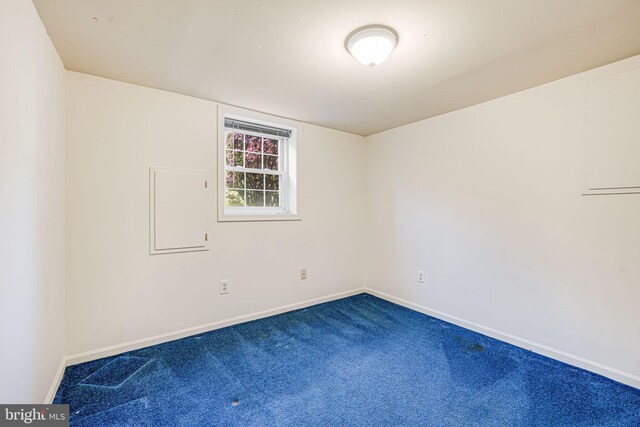 carpeted spare room featuring baseboards