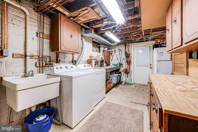 washroom with a sink, cabinet space, and washing machine and clothes dryer