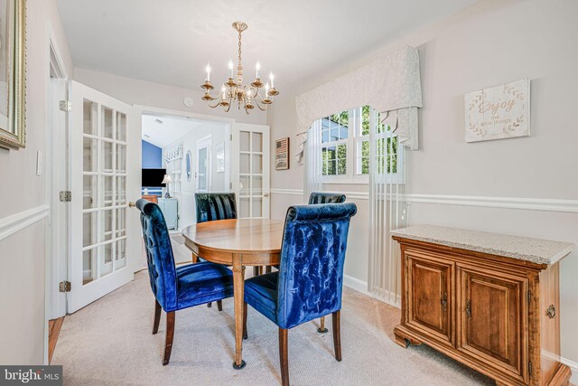 dining room featuring french doors, light carpet, and an inviting chandelier
