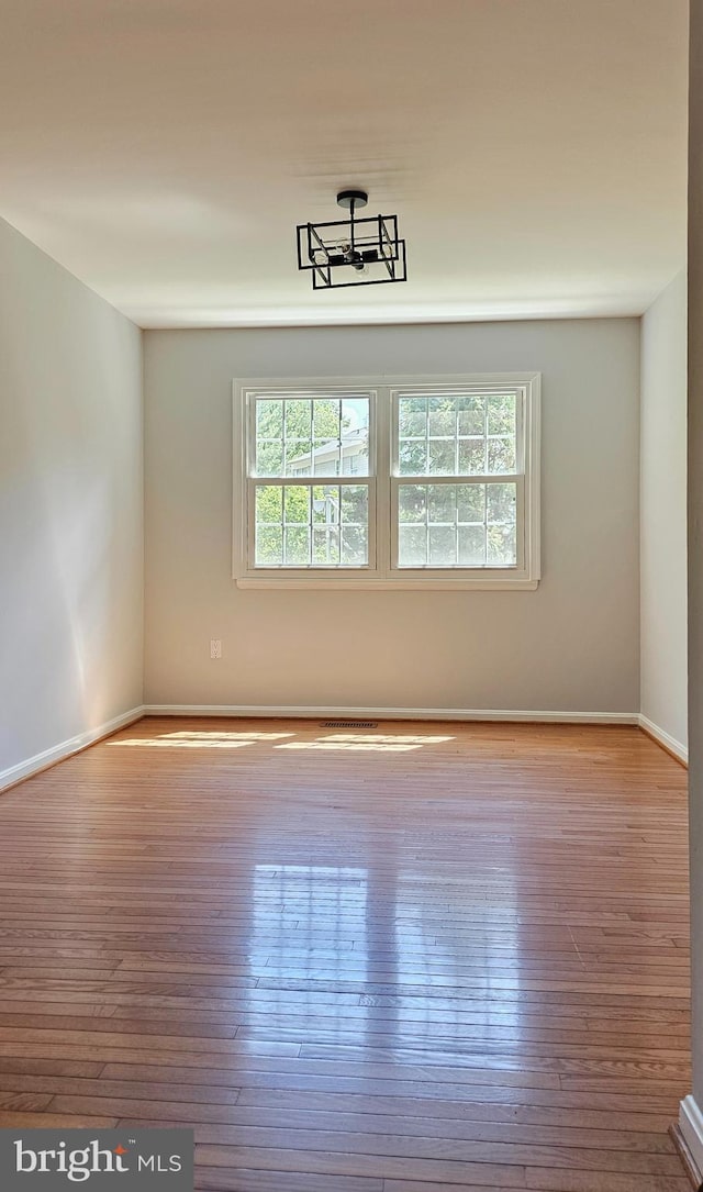 unfurnished room featuring baseboards and hardwood / wood-style flooring