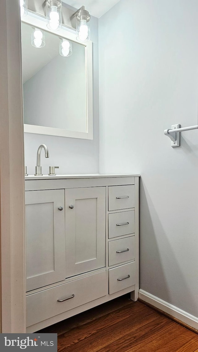 bathroom featuring baseboards, vanity, and wood finished floors