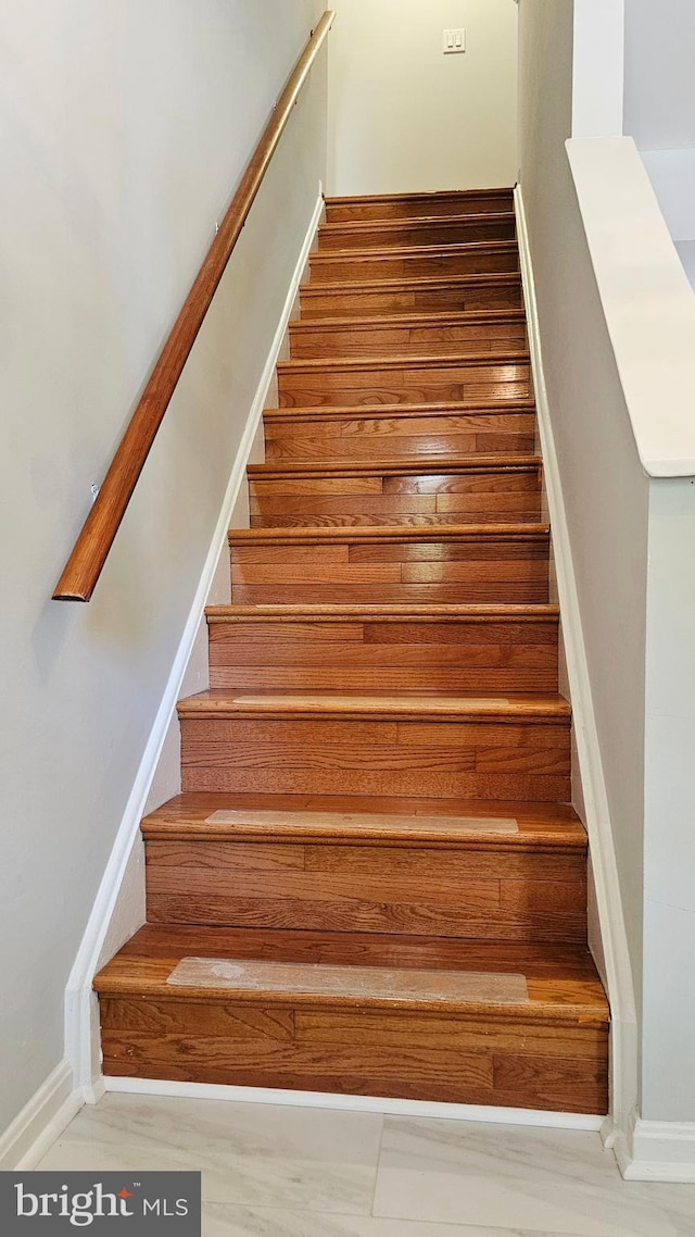 staircase featuring baseboards