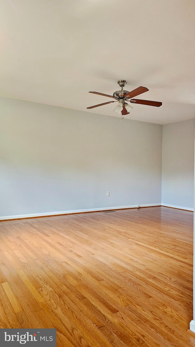 spare room with baseboards, a ceiling fan, and wood finished floors