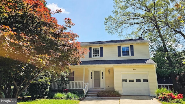 view of front of property featuring a garage, concrete driveway, and a porch