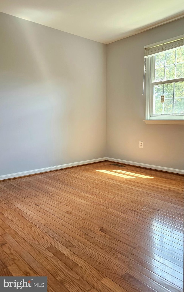 empty room with baseboards and wood finished floors