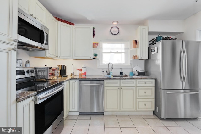 1306 Bayshore Ave, Brigantine, NJ 08203 - kitchen with stainless steel appliances, light tile patterned floors, a sink, and dark stone countertops