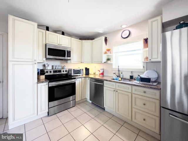 1306 Bayshore Ave, Brigantine, NJ 08203 - kitchen featuring light tile patterned flooring, appliances with stainless steel finishes, a sink, stone counters, and cream cabinetry