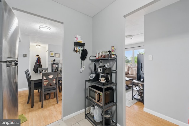 hall featuring light wood-style floors and baseboards