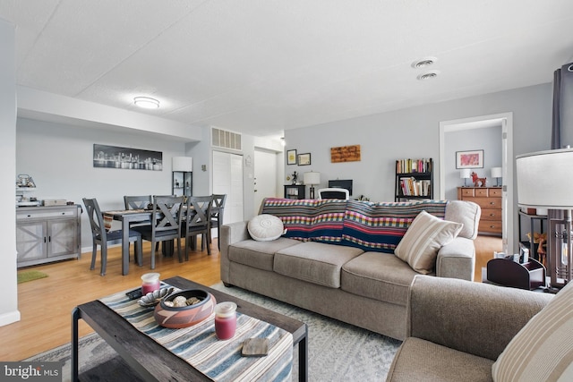 living area with baseboards and wood finished floors