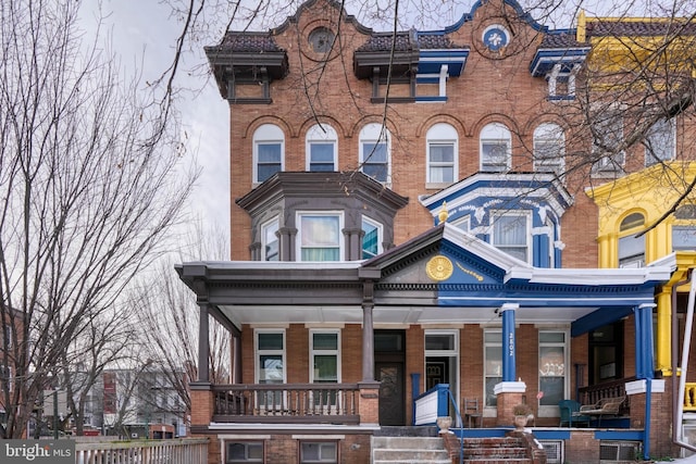 exterior space with covered porch and brick siding