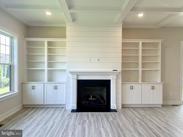 unfurnished living room with baseboards, light wood-type flooring, a healthy amount of sunlight, and coffered ceiling