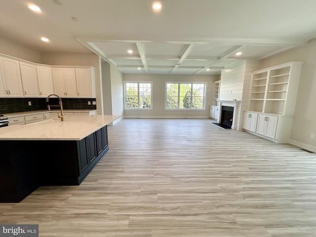kitchen featuring recessed lighting, open floor plan, light wood finished floors, and coffered ceiling