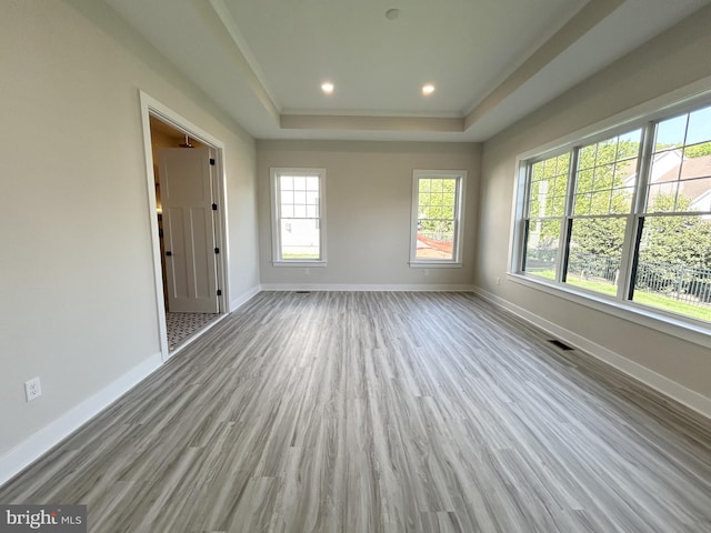 unfurnished room featuring baseboards, a tray ceiling, recessed lighting, and wood finished floors