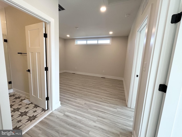 below grade area featuring recessed lighting, light wood finished floors, and baseboards