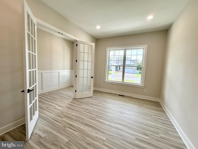 empty room with baseboards, visible vents, french doors, and light wood-style floors