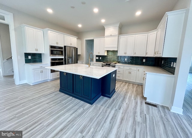 kitchen with light countertops, white cabinetry, appliances with stainless steel finishes, and backsplash