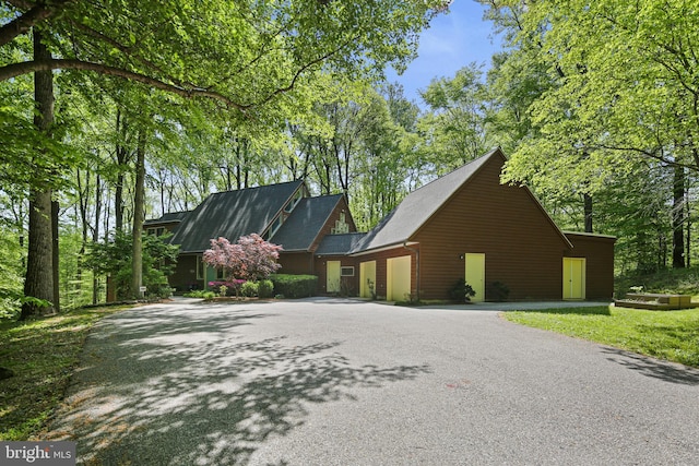 view of side of home with a garage and aphalt driveway