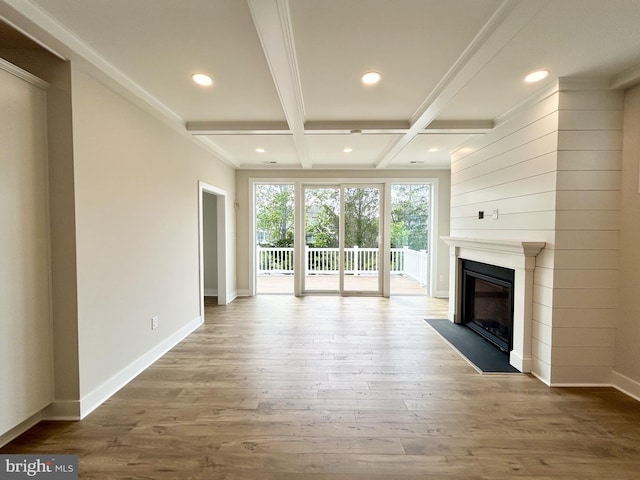 unfurnished living room featuring beam ceiling, baseboards, a fireplace with flush hearth, wood finished floors, and coffered ceiling