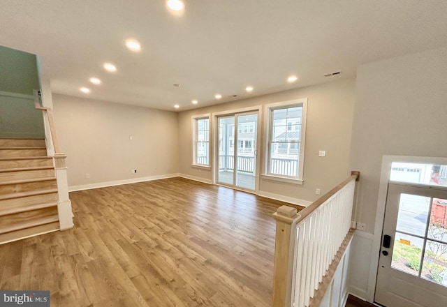 unfurnished living room featuring recessed lighting, wood finished floors, and a healthy amount of sunlight