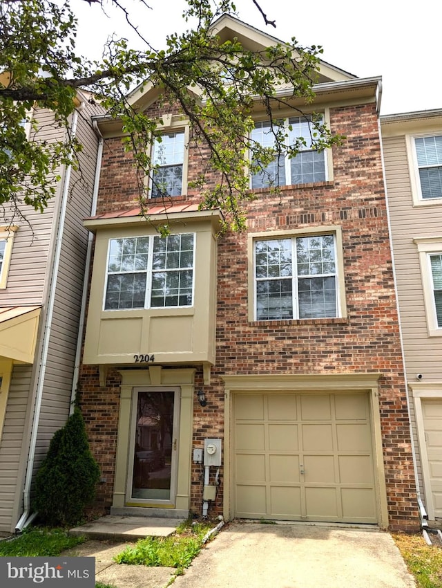 view of property with driveway, brick siding, and a garage