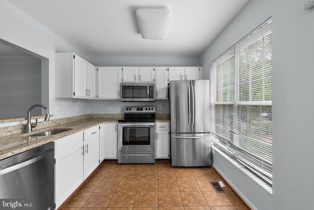 2204 Commissary Cir, Odenton, MD 21113 - kitchen featuring appliances with stainless steel finishes, a sink, light stone counters, white cabinetry, and light tile patterned floors