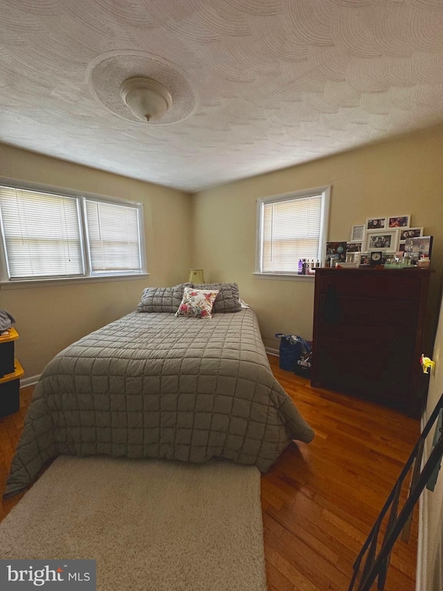 128 Fox Dr, Winchester, VA 22601 - bedroom with wood finished floors, multiple windows, and a textured ceiling