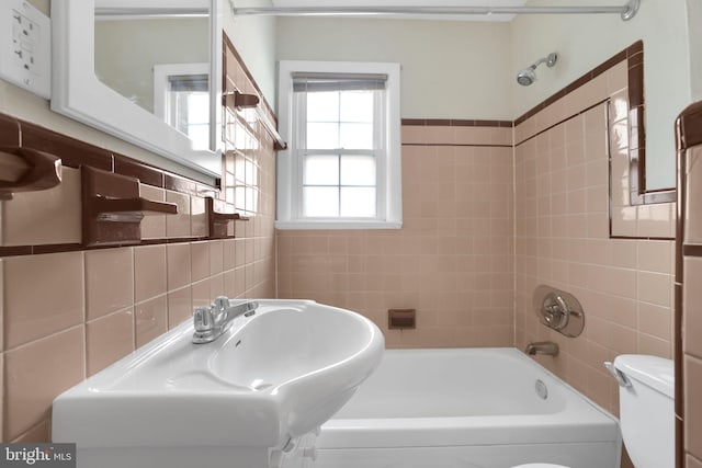 128 Fox Dr, Winchester, VA 22601 - bathroom with toilet, tile walls, washtub / shower combination, and a sink
