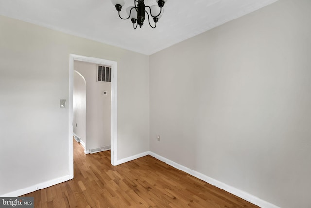 128 Fox Dr, Winchester, VA 22601 - spare room featuring a chandelier, baseboards, wood finished floors, and arched walkways