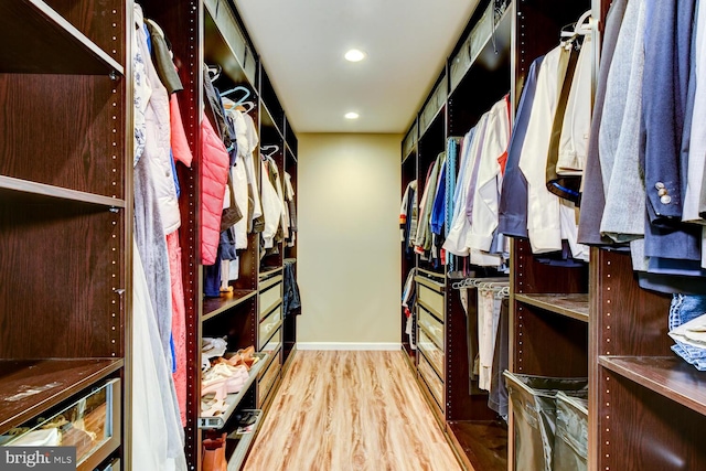 walk in closet with wood finished floors