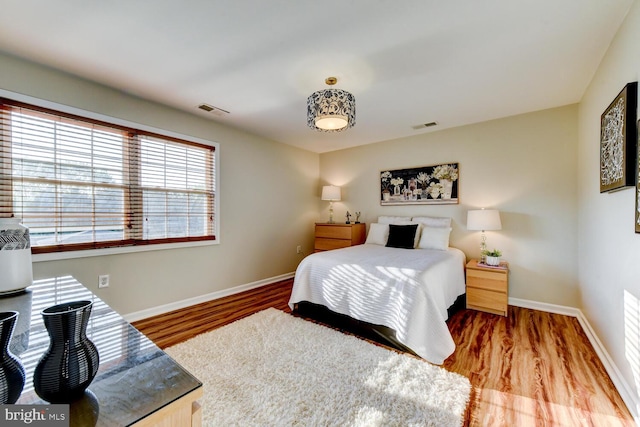 bedroom featuring baseboards and wood finished floors